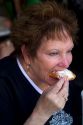 Woman eating a beignet at Cafe Du Monde in the French Quarter of New Orleans, Louisiana, USA.