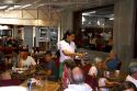 Server with customers in a restaurant at Necochea, Argentina.