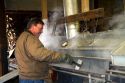 Worker boiling maple sap in a sugar shack at Lake Odessa, Michigan, USA.