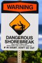 Beach sign warning of dangerous shorebreak on the island of Kauai, Hawaii, USA.
