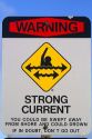 Beach sign warning of strong current and on the island of Kauai, Hawaii, USA.