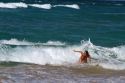 Woman in the pacific ocean at Polihale Beach and State Park located on the western side of the island of Kauai, Hawaii, USA.