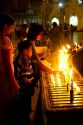 A young boy lighting a candle at the Shwedagon Paya located in (Rangoon)Yangon, (Burma) Myanmar.