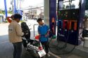 Gas station attendent filling up a motor scooter on the island of Ko Samui, Thailand.