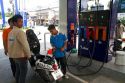Gas station attendent filling up a motor scooter on the island of Ko Samui, Thailand.