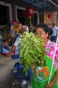 Grocer smelling fresh bay leaves being offered for sale by the grower on the island of Ko Samui, Thailand.