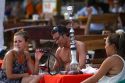 Tourists smoke flavored tobacco out of a hookah at Chaweng beach in the Gulf of Thailand on the island of Ko Samui, Thailand.