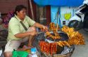 Food vendor grilling meat over a charcoal fire at Chaweng beach on the island of Ko Samui, Thailand.