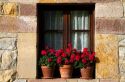 Flower pots in the window of a building in the village of Santillana del Mar, Cantabria, Spain.
